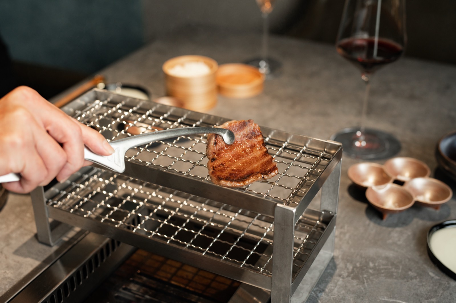櫓（やぐら）の網の上で焼き上げた和牛を休ませる